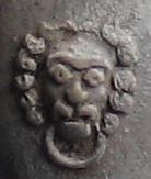 Reli�fmerk leeuwenkop met ring in de bek 